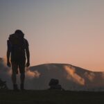 trekking, foto di uomo al tramonto su sentiero di montagna