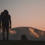 trekking, foto di uomo al tramonto su sentiero di montagna