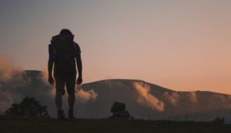 trekking, foto di uomo al tramonto su sentiero di montagna