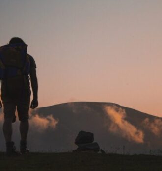 trekking, foto di uomo al tramonto su sentiero di montagna