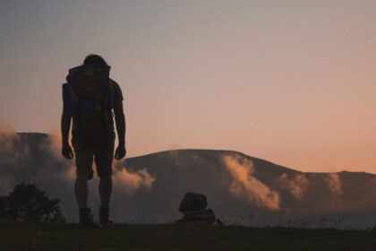 trekking, foto di uomo al tramonto su sentiero di montagna