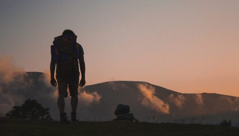 trekking, foto di uomo al tramonto su sentiero di montagna